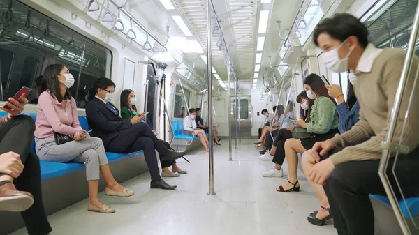 Multidão de pessoas usando máscara facial em uma viagem de trem de metrô público lotado — Fotografia de Stock