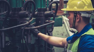 Fabrika atölyesinde makine kullanan akıllı bir fabrika işçisi