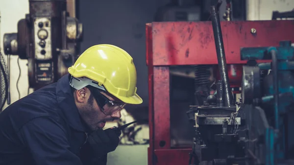 Fabrika işçisi, makine parçalarını incelerken taşınabilir radyodan konuşuyor. — Stok fotoğraf