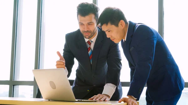 Two business people talk project strategy at office