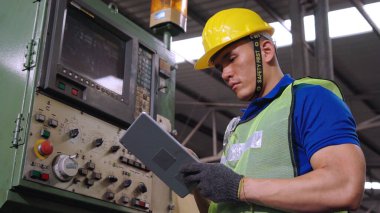 Fabrika atölyesinde makine kullanan akıllı bir fabrika işçisi