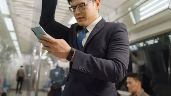Empresário que utiliza telemóvel no comboio público — Fotografia de Stock