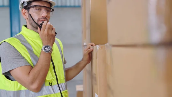 Trabalhador de carga profissional fala em rádio portátil para entrar em contato com outro trabalhador — Fotografia de Stock