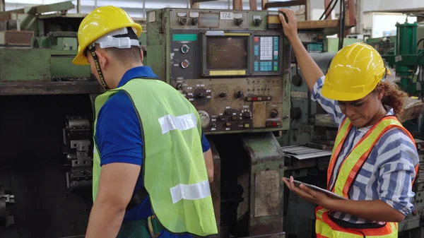 Groep fabrieksarbeiders die machineapparatuur gebruiken in fabriekswerkplaats — Stockfoto