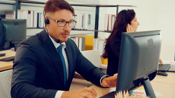 Vezetékes fülhallgatót viselő üzletemberek az irodában — Stock Fotó