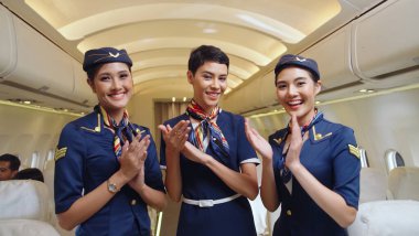 Kabin ekibi uçakta el çırpıyor.