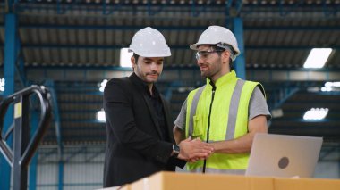 Fabrikada çalışan ve üretim planını tartışan iki fabrika işçisi. .