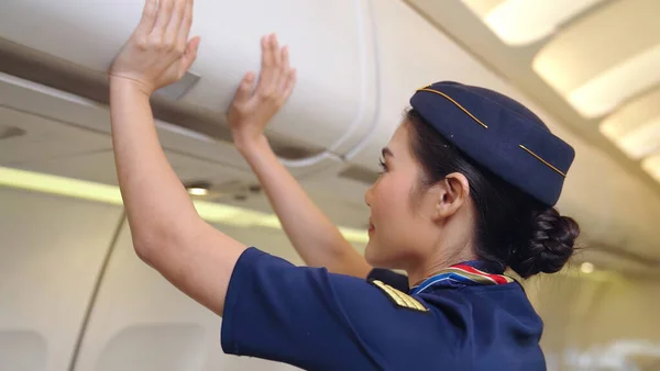 Kabinenpersonal hebt Gepäcktasche im Flugzeug — Stockfoto