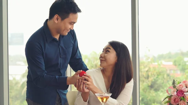 Romantic couple giving gift to lover at restaurant — Stock Photo, Image