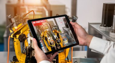 Mühendis, artırılmış gerçeklik endüstrisi teknolojisiyle robotik kolları kontrol ediyor.