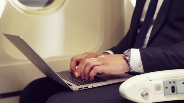 Joven hombre de negocios usando computadora portátil en avión — Vídeos de Stock