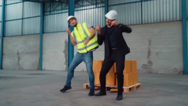 Grappige fabrieksarbeiders dansen in de fabriek — Stockvideo