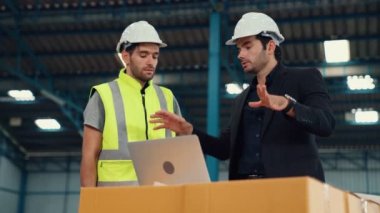 Fabrikada çalışan ve üretim planını tartışan iki fabrika işçisi. .