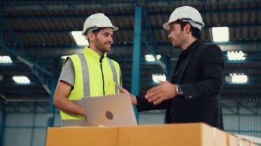Fabrikada çalışan ve üretim planını tartışan iki fabrika işçisi. .