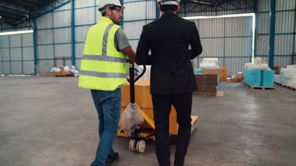 Заводські робітники доставляють коробки пакету на штовхаючий візок на складі  . — стокове відео