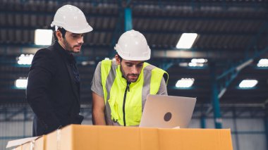 Fabrikada çalışan ve üretim planını tartışan iki fabrika işçisi. .