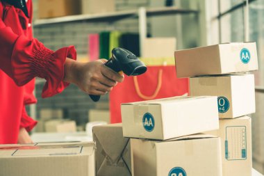 Çevrimiçi satıcı ev ofisinde çalışıyor ve teslimat kutusunu müşteriye paketliyor..
