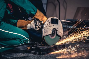 Profesyonel tamirci dönen karbon bıçağıyla çelik metali kesiyor.