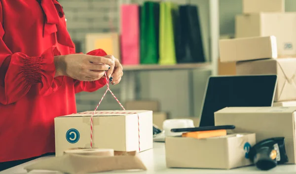 Vendeur en ligne travaille au bureau à domicile et emballe la boîte de livraison au client. — Photo