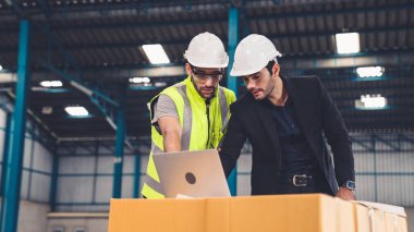 Fabrikada çalışan ve üretim planını tartışan iki fabrika işçisi. .