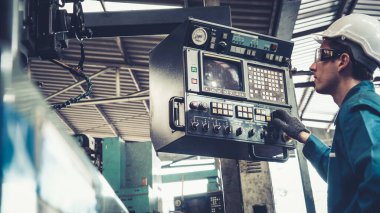 Fabrika atölyesinde makine kullanan akıllı bir fabrika işçisi