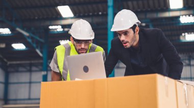 Fabrikada çalışan ve üretim planını tartışan iki fabrika işçisi. .