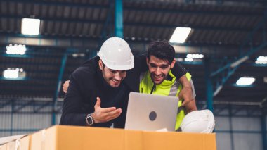 İki fabrika işçisi fabrikada başarıyı birlikte kutluyor.