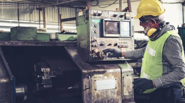 Fabrika atölyesinde makine kullanan akıllı bir fabrika işçisi