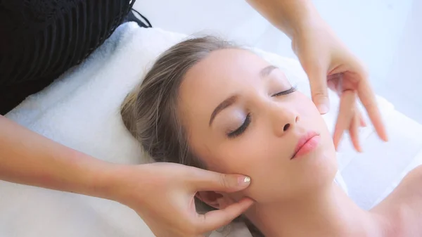 Kobieta dostaje masaż twarzy i głowy w luksusowym spa. — Zdjęcie stockowe