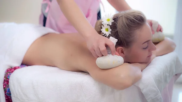 Massage therapist using herbal compress with woman — Stock Photo, Image