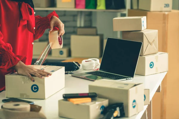 El vendedor en línea trabaja en la oficina de casa y empaca la caja de envío al cliente. — Foto de Stock