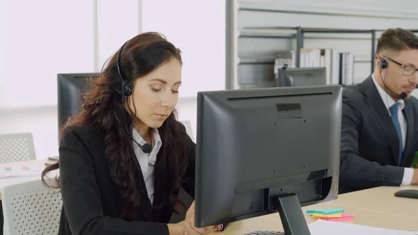 Zakenmensen met een koptelefoon aan het werk — Stockfoto