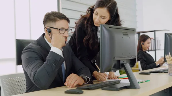 Zakenmensen met een koptelefoon aan het werk — Stockfoto