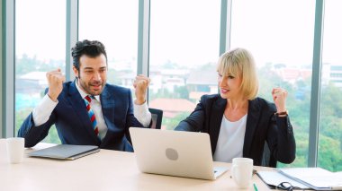 İki mutlu iş adamı ofiste kutlama yapıyor.