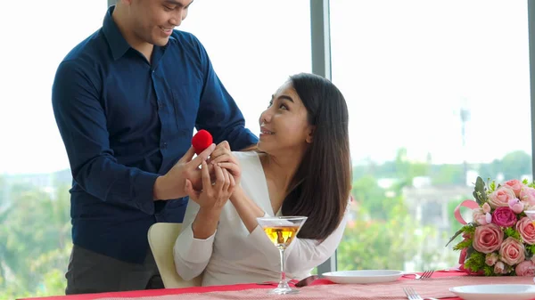 Romantic couple giving gift to lover at restaurant — Stock Photo, Image