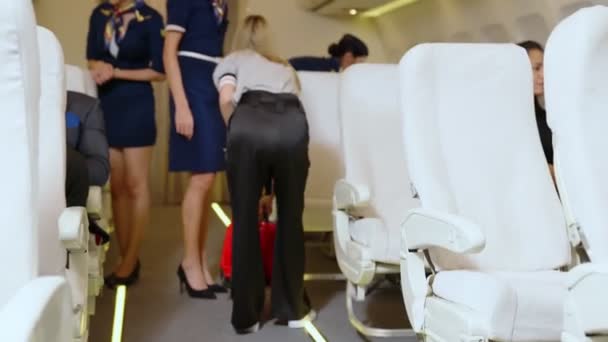 Cabin crew lift luggage bag in airplane — Stock Video