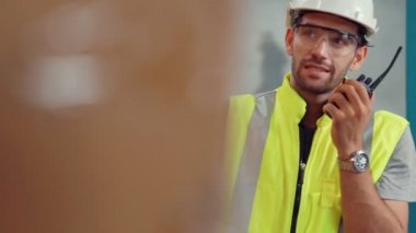Profesyonel kargo işçisi başka bir işçiyle bağlantı kurmak için telsizle konuşuyor.