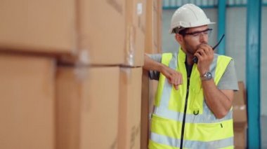 Profesyonel kargo işçisi başka bir işçiyle bağlantı kurmak için telsizle konuşuyor.