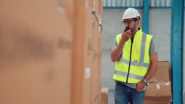Profesyonel kargo işçisi başka bir işçiyle bağlantı kurmak için telsizle konuşuyor.