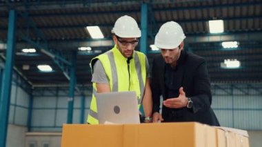 Fabrikada çalışan ve üretim planını tartışan iki fabrika işçisi. .