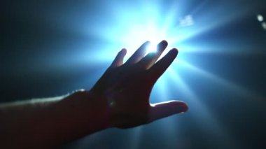 Parlayan ışığı kapatmak için uzanan el.