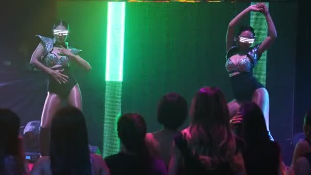 Grupo de personas bailan en discoteca al ritmo de la música de DJ en el escenario — Vídeos de Stock