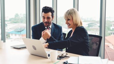 İki mutlu iş adamı ofiste kutlama yapıyor.