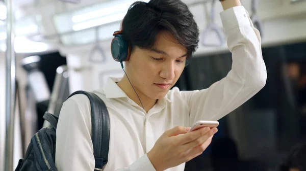 Empresario usando teléfono móvil en tren público — Foto de Stock