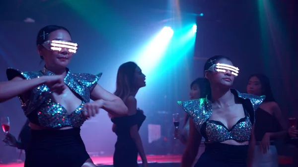 Groupe de personnes dansent en discothèque au rythme de la musique de DJ sur scène — Photo
