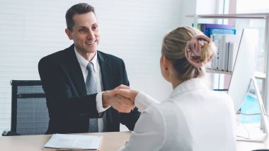 İş görüşmesinde iş arayan ve yönetici el sıkışması