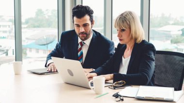 İki iş adamı ofiste proje stratejisi hakkında konuşuyor