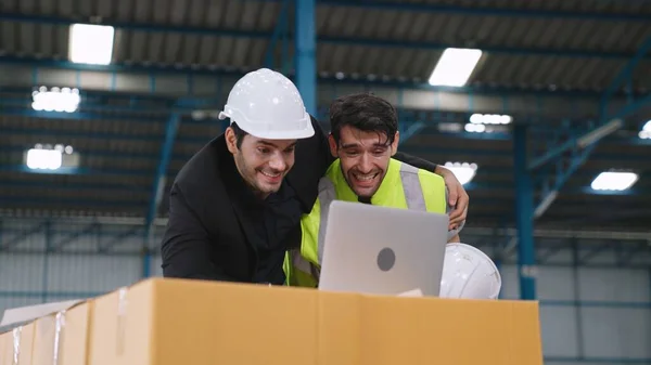 Two factory worker celebrate success together in the factory