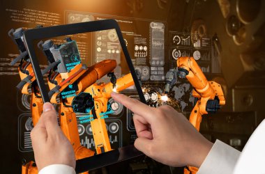 Mühendis, artırılmış gerçeklik endüstrisi teknolojisiyle robotik kolları kontrol ediyor.