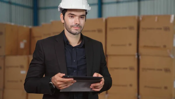 Factory manager using tablet computer in warehouse or factory